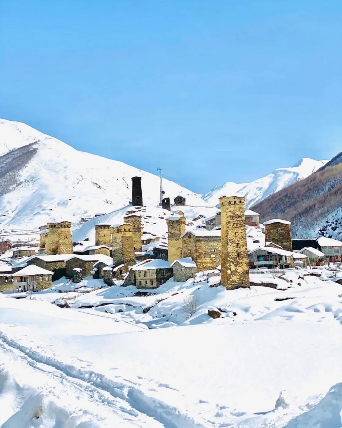 Snow-covered stone towers of Ushguli in winter