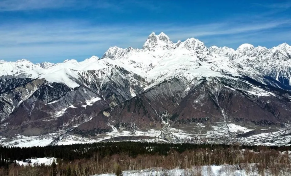 Snow-covered Caucasus range under a blue sky