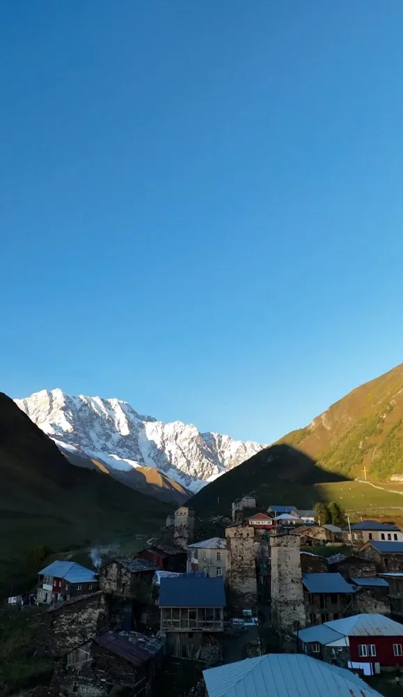 Stone village below a snow-capped mountain in the Caucasus