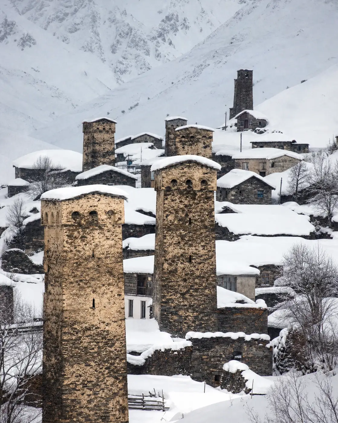 Snow-covered stone towers of Ushguli in winter
