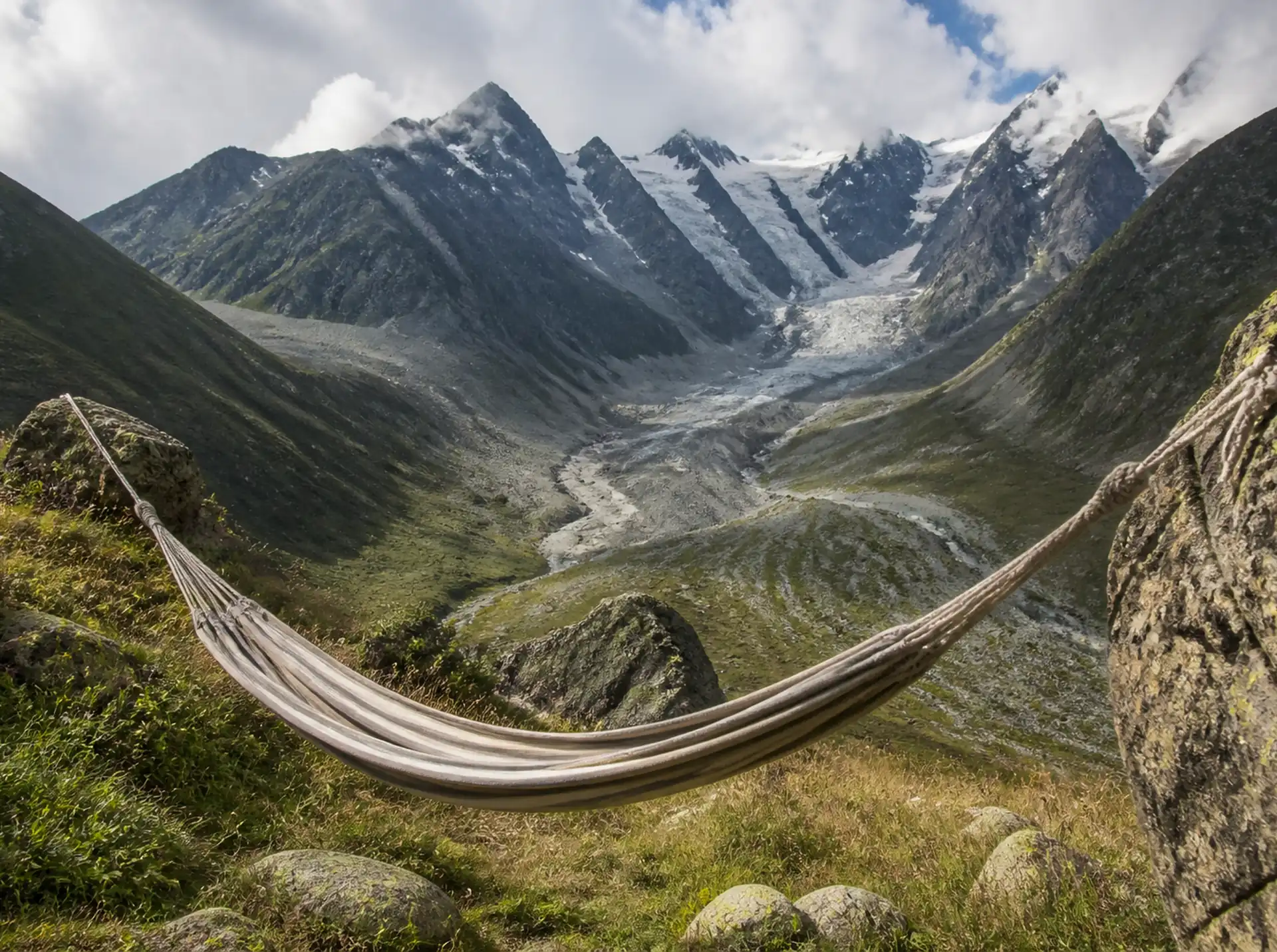 Hammock strung in a glacier valley below the Caucasus peaks